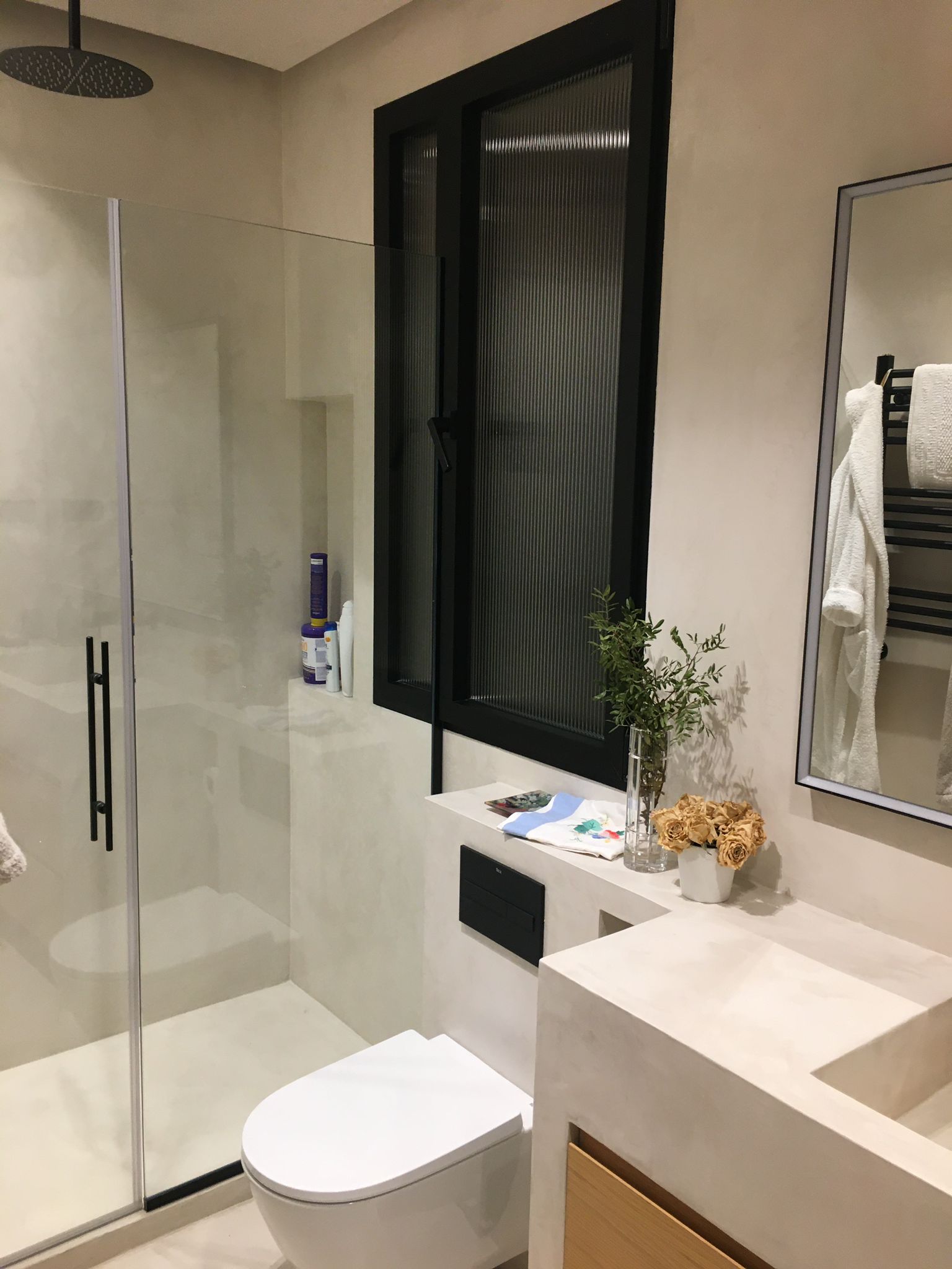 Baño real con ducha y superficies de microcemento