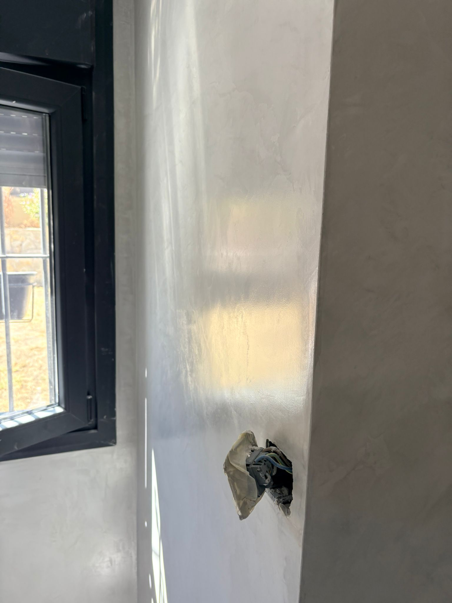 Pared revestida junto a una ventana oscura