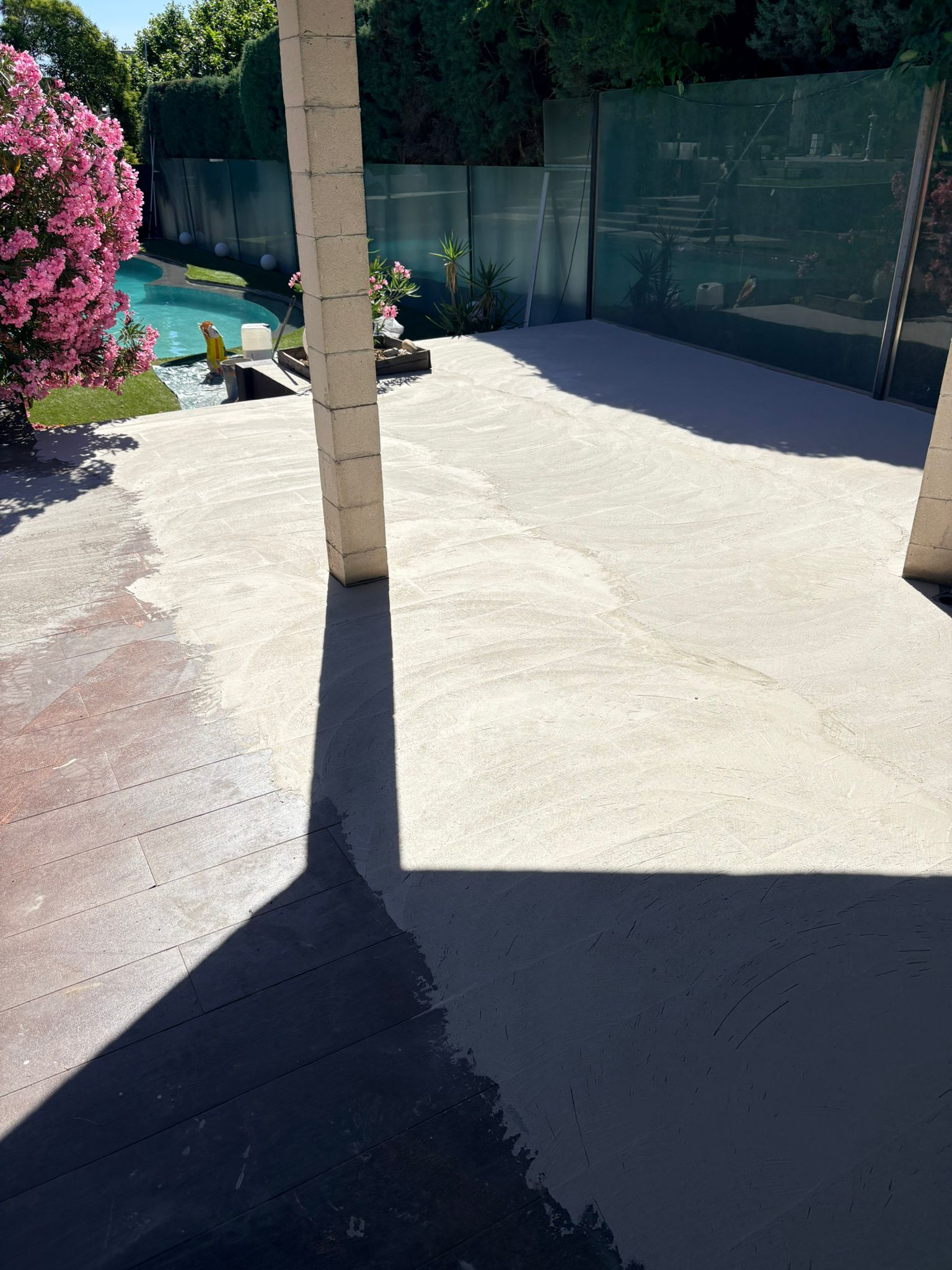 Aplicación de pavimento continuo en terraza junto a una piscina