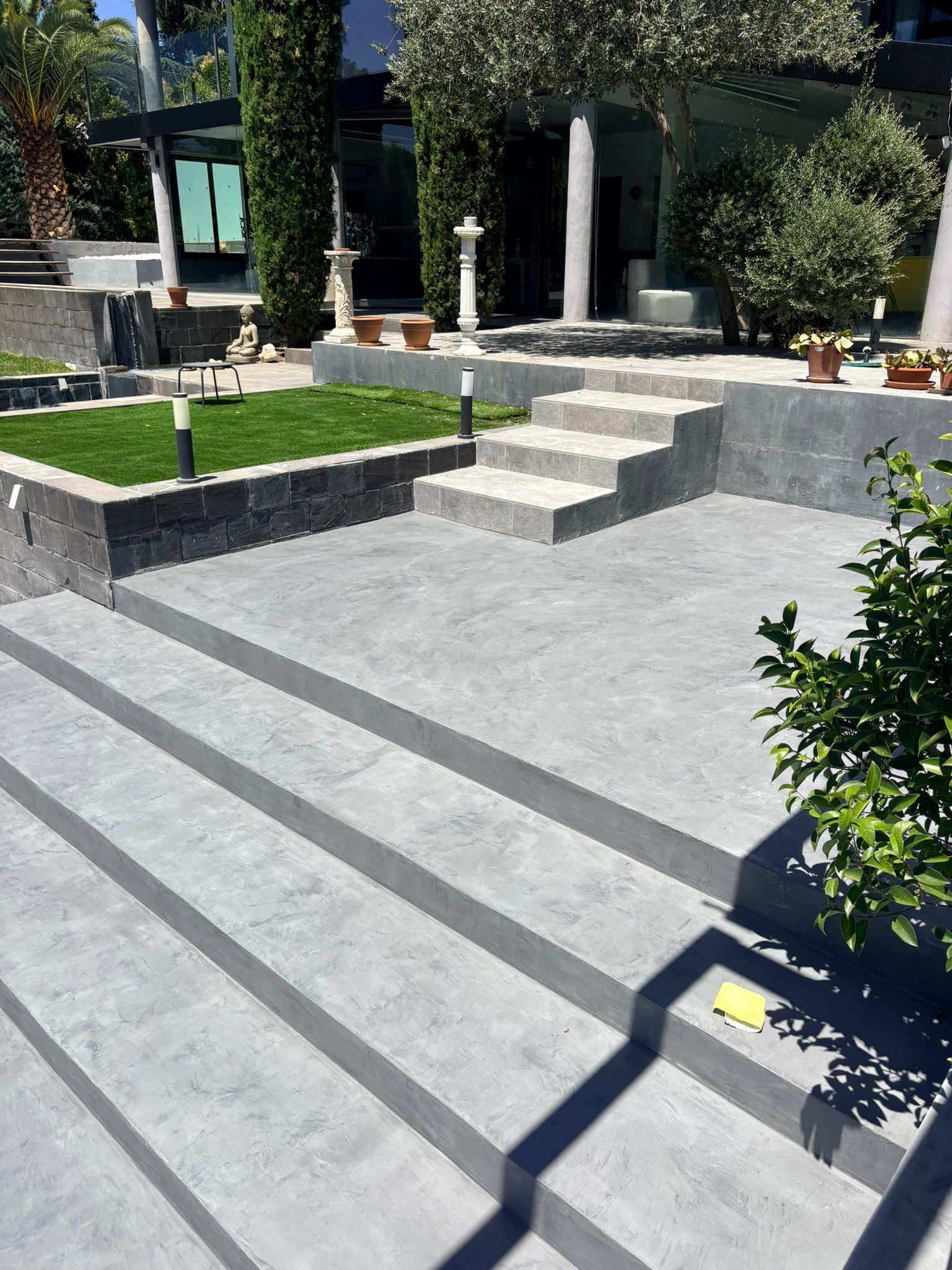 Escaleras y acceso exterior revestidos con acabado continuo