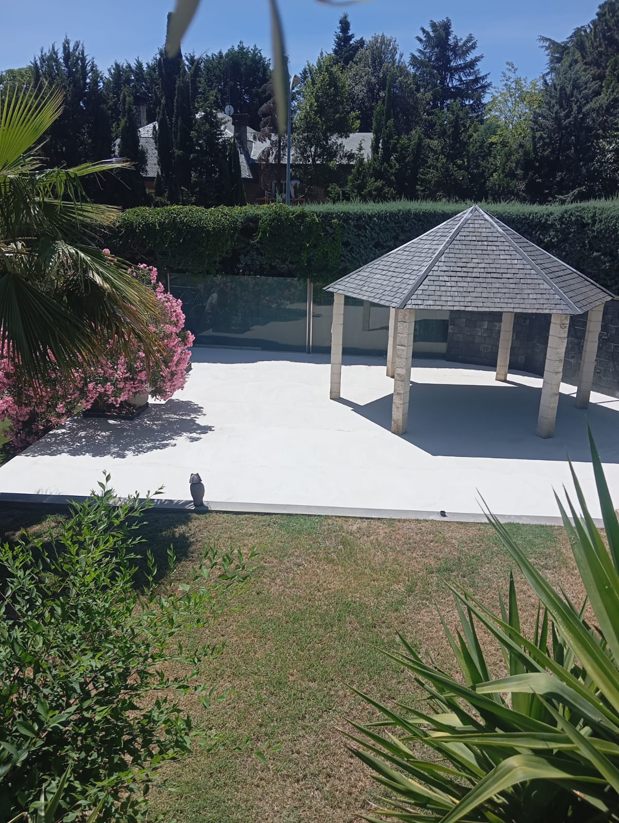 Terraza exterior con pavimento continuo y zona ajardinada